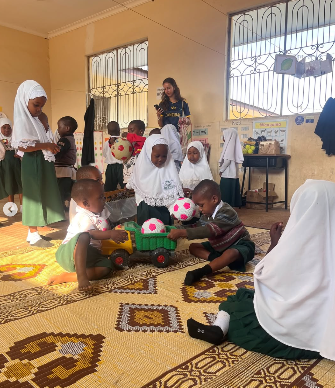 Children playing with toys and footballs in a classroom at Kiembe Samaki School in Zanzibar